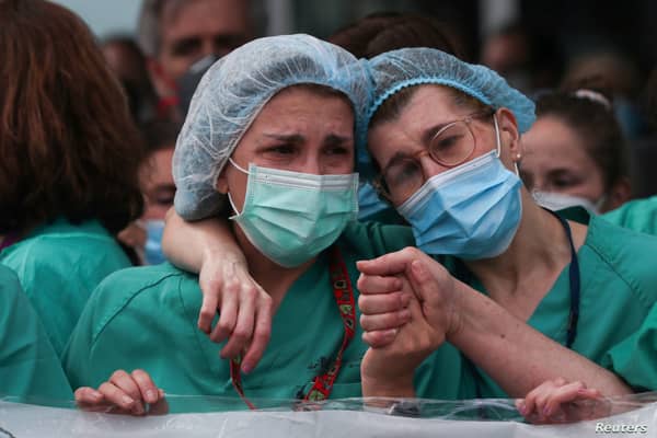 Health workers wearing protective face masks react during a tribute for their co-worker Esteban, a male nurse that died of the coronavirus disease, amid the coronavirus disease (COVID-19) outbreak, outside the Severo Ochoa Hospital in Leganes, Spain, April 13, 2020. REUTERS/Susana Vera     TPX IMAGES OF THE DAY