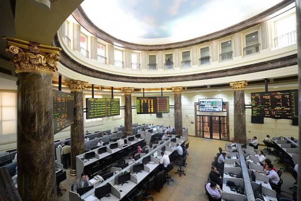 FILE - In this Saturday, March 10, 2013 file photo, Egyptian traders work on the floor of the stock market in Cairo, Egypt. On Sunday, June 1, 2014, Egypts benchmark index plunged, with a temporary suspension of trading failing to cool a frenzy of selling by investors panicked by a newly proposed government tax on capital gains. The market slide was sparked by an announcement from the finance minister that the government will impose a 10 percent tax on net realized portfolio profit at year end. Profits from the stock market are currently tax-free. (AP Photo/Amr Nabil, File)