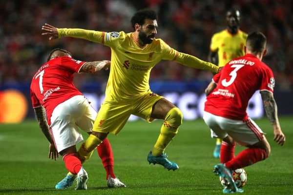Liverpool's Egyptian midfielder Mohamed Salah (C) fights for the ball with Benfica's Brazilian forward Everton (L) and Benfica's Spanish defender Alex Grimaldo during the UEFA Champions League quarter final first leg football match between SL Benfica and Liverpool FC at the Luz stadium in Lisbon on April 5, 2022. (Photo by CARLOS COSTA / AFP) (Photo by CARLOS COSTA/AFP via Getty Images)