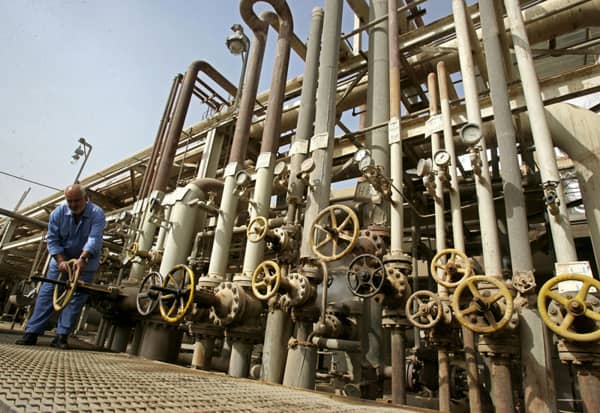 BAGHDAD, IRAQ - NOVEMBER 5: An Iraqi worker adjusts a control valves at the Daura oil refinery on November 5, 2009 in Baghdad, Iraq. Iraq and a grouping of U.S and European oil companies Exxon Mobil Corp and Royal Dutch Shell PLC signed a $50 billion contract today to develop the West Qurna oilfield, two days after the Iraqi South Oil Company signed a technical service contract with Britain's BP and China's CNPC to develop the Rumaila oilfield. The Iraqi government is trying to attract foreign investment, especially in the oil sector, in hopes of reviving its war-torn economy. Iraq has the third largest oil reserve in the world but it is producing way below its potential.  (Photo by Muhannad Fala'ah/Getty Images)