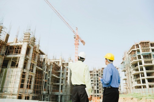 Two male architects planning on building site